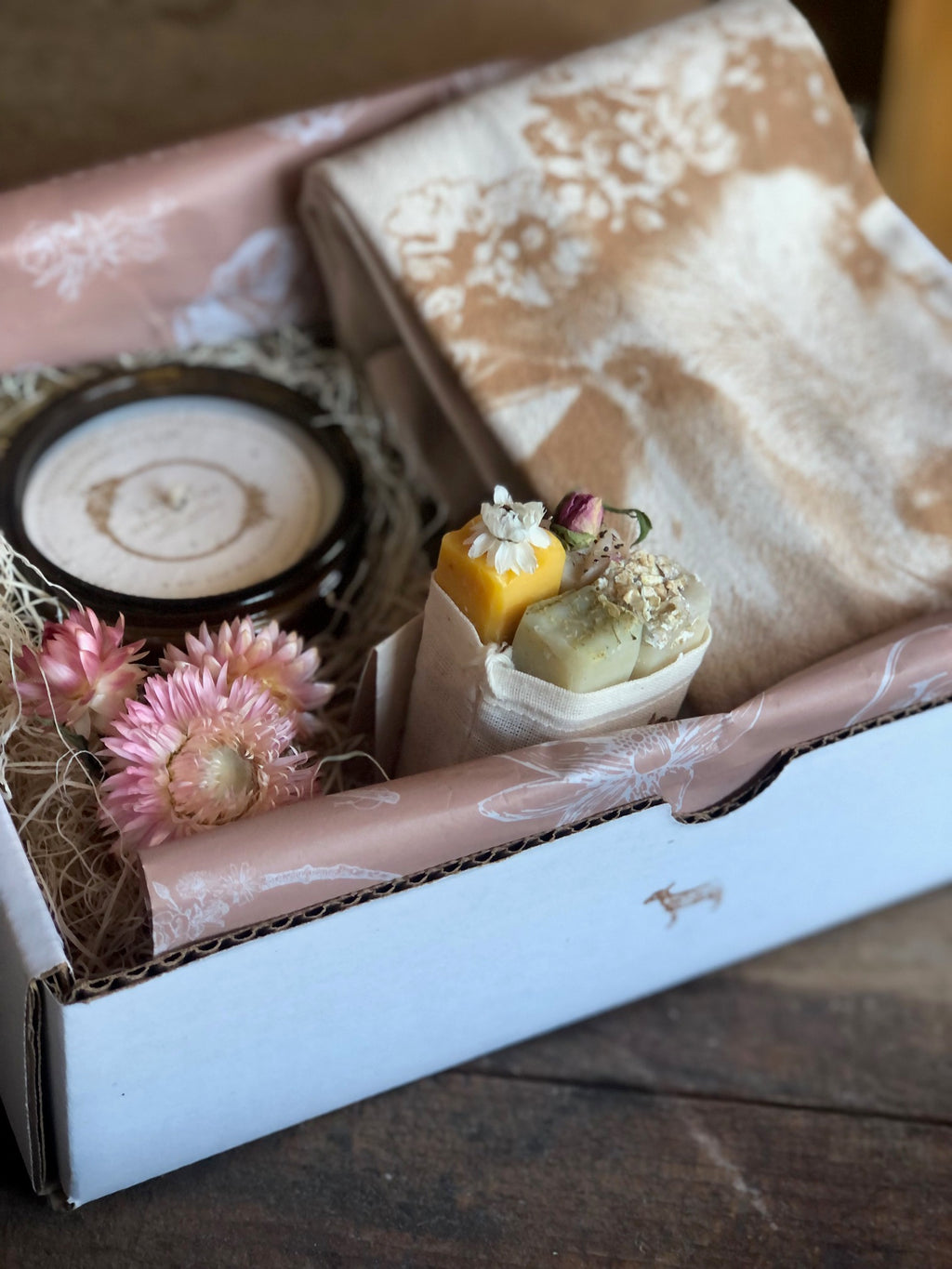 Gift box with candle, soap bouquet, dried flowers, and tea towel with goat Carmen in a flower crown